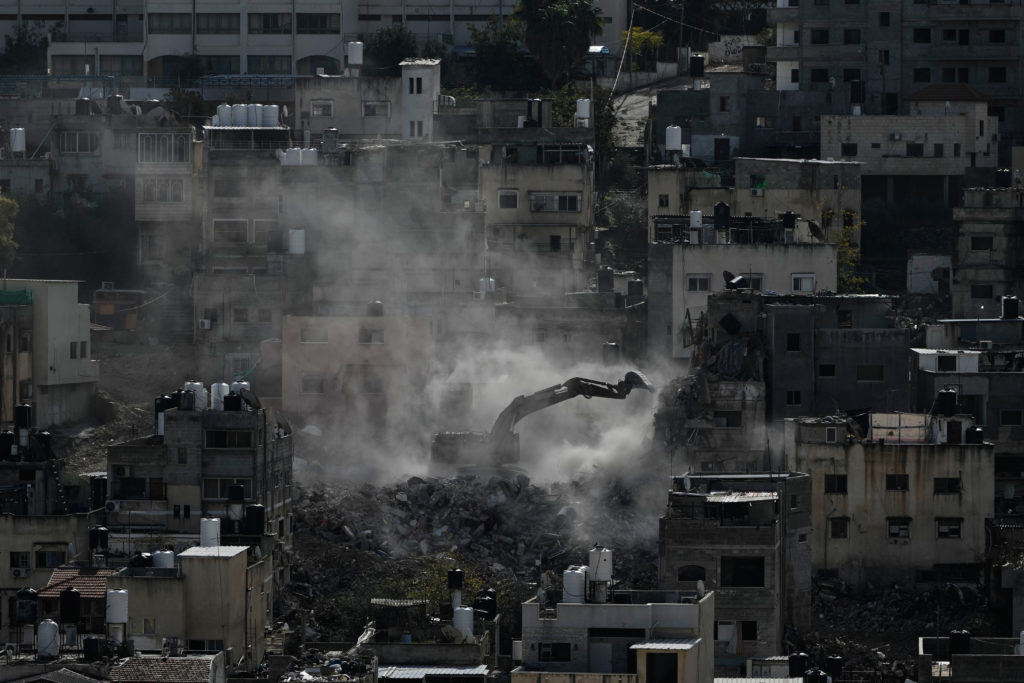 Palestinians watch as Israeli bulldozers claw down their West Bank homes